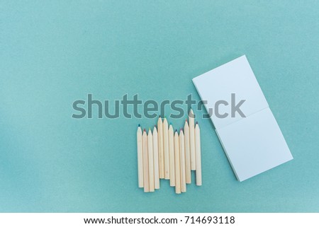 Pencil, color pencil and note paper on wood blue background, for education and business. Top view.