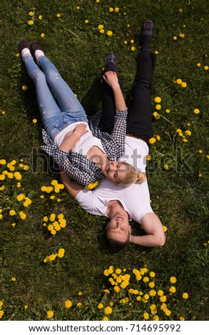 Overhead view of young man and woman lying on the grass, Top view of relaxed young couple lying down on meadow.