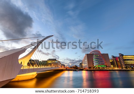 Barrel shaped Dublin Convention Center and Samuel Beckett Bridge reflecting in the river Liffey, Dublin , Ireland Royalty-Free Stock Photo #714718393