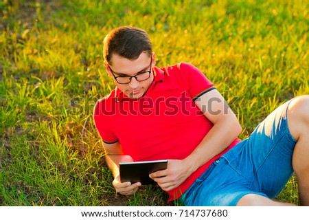 young man with tablet pc in autumn park