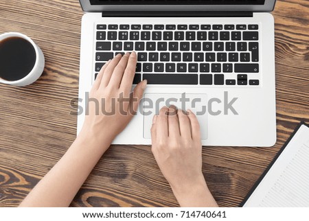 Young woman using laptop for searching information in internet at table