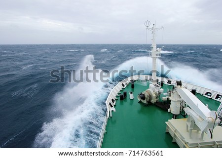 Ship's Bow diving into a big splashing wave, antarctic ocean, Antarctica Royalty-Free Stock Photo #714763561