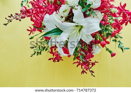 Flat lay of spring flowers bouquet, branches and leaves on yellow background in Top view