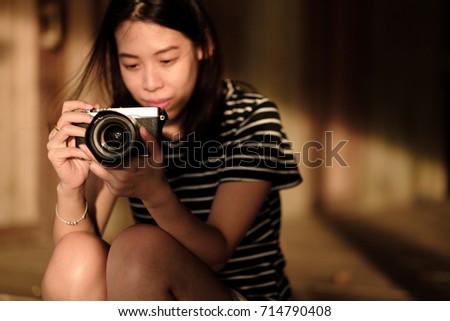 Young asian woman holding vintage camera.