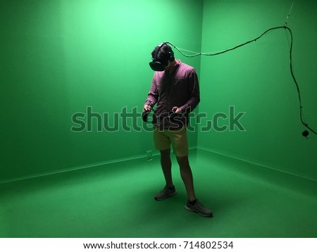 Man in Virtual reality augmented reality arcade - VR experience center. Man interacts with headset that embodies physical spaces or multi-projected environments