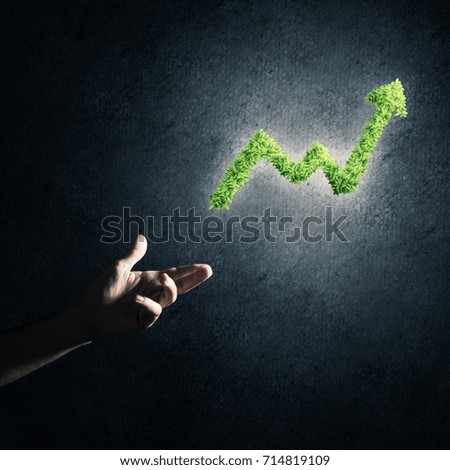 Close of businessman hand and green growing graph as symbol of progress and income