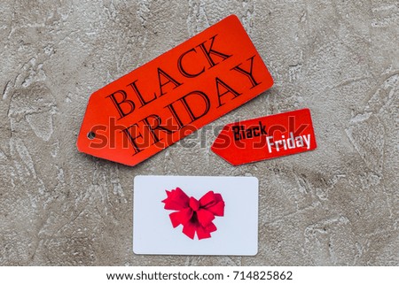 Words black friday on red labels near card on light background top view