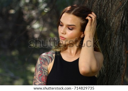 Beautiful portrait blonde with a tattoo on a hand in casual style outdoors.