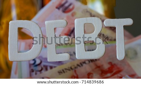 Debt signage with Singaporean dollars in the background.