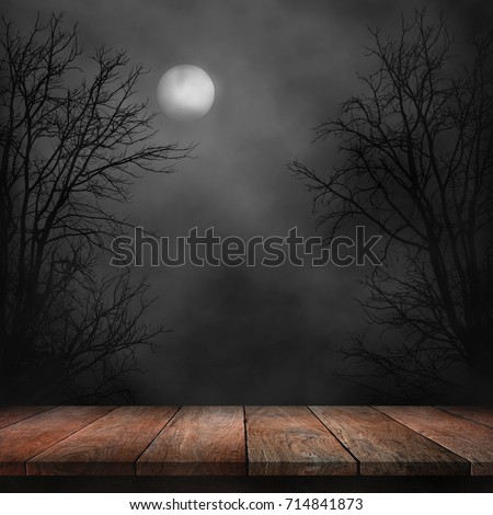 Old wood table and silhouette dead tree at night for Halloween background. Royalty-Free Stock Photo #714841873