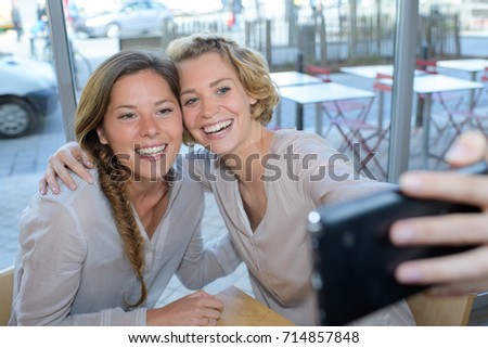 Two women taking selfie with cellphone