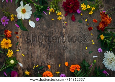 Garden flowers on the wooden table. Flower frame, top view