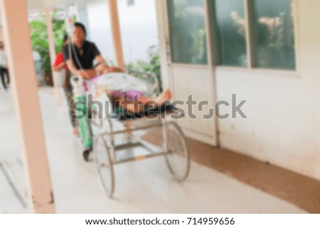 Transfers patient in hospital as blurred image for background.
