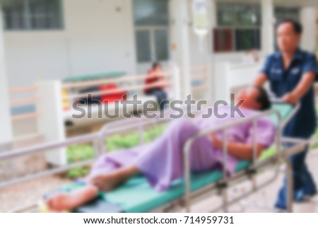Transfers patient in hospital as blurred image for background.

