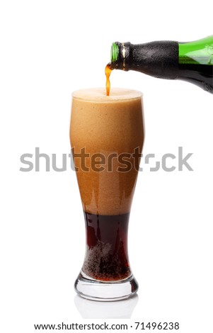 Pouring a glass of dark beer isolated on white background