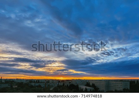 Sky with clouds at sunrise over morning city.