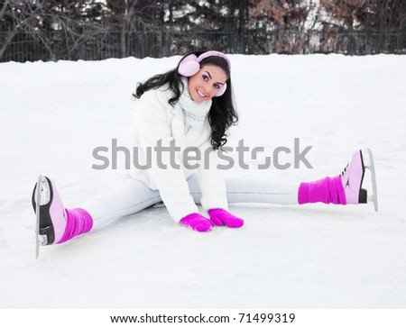 happy beautiful girl wearing warm winter clothes ice skating