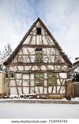 A very old and overgrown half-timbered house  in Lachen, Neustadt an der Weinstrasse, Germany with snow.