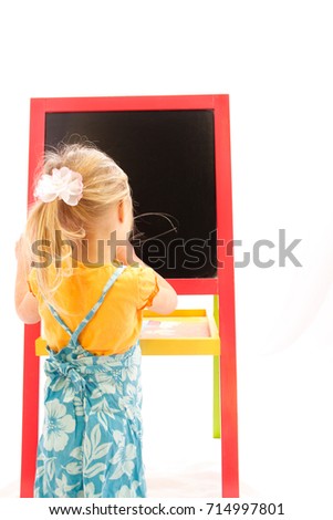 Happy baby girl beautiful painting on the easel on a white background