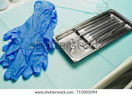 Close-up of dentist's tools and blue latex gloves and mask top view