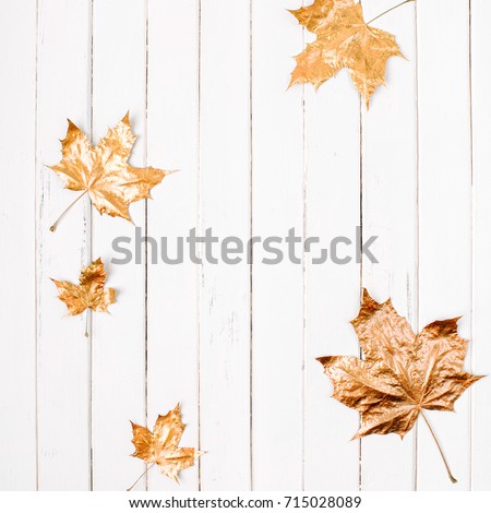 Golden maple leaves on a white wooden background. Autumn concept