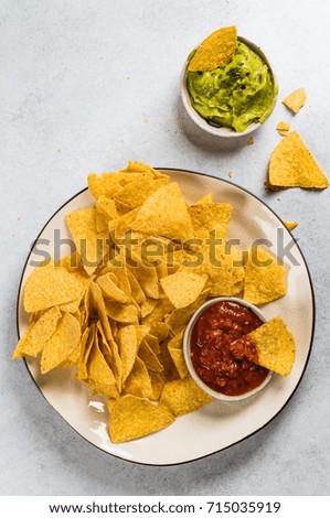 Nachos with salsa and guacamole on light background