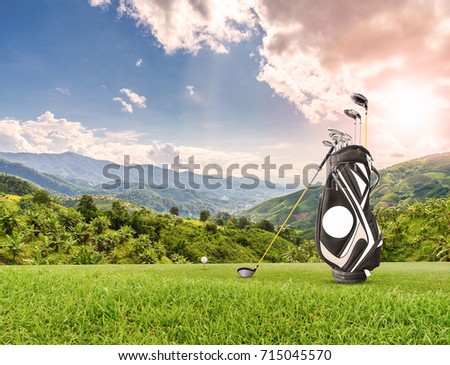 Golf equipment , golf ball, golf bag  and driver ( wood-1) on green as mountain background.