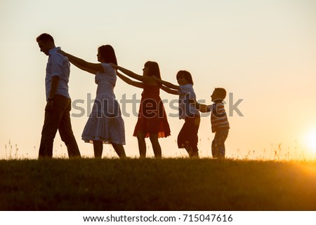 silhoutte of happy family enjoying themself on cliff