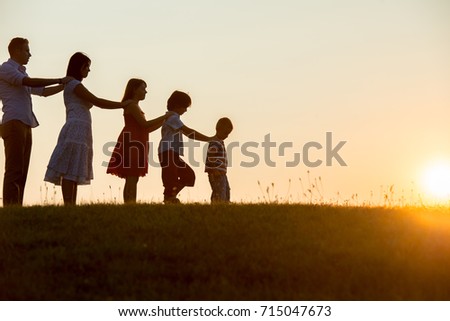 silhoutte of happy family enjoying themself on cliff