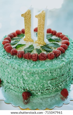 Green cake with number 11 on the table