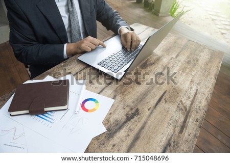 businessmen using laptop analyzing marketing strategy with statistic graph and notebook on wooden desk.stock trading analysis.