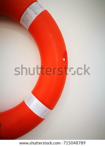 Partial view of orange buoy isolated, hanging on the white wall.