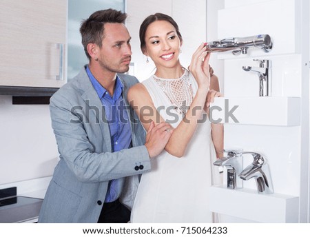 family couple looking at modern kitchen