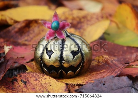 Scary golden pumpkin with small flower on the head