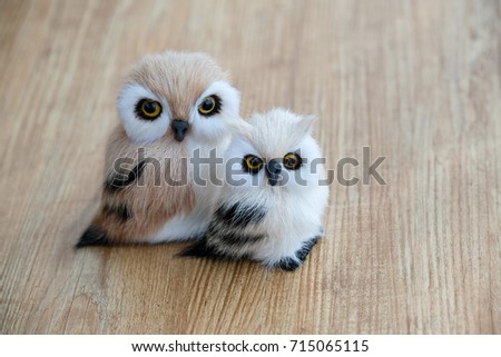 Owl model on wooden background. Owl toy on brown background. Owl doll.