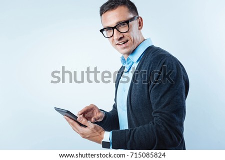 Pensive guy with digital tablet looking into camera