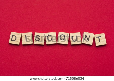 Discount word on wooden tiles isolated on red background