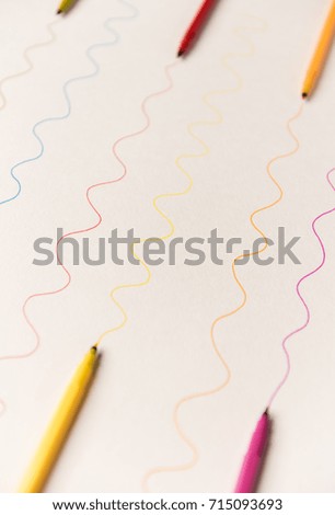 Different wavy lines painted with colorful markers on white paper. Lines for logo, text