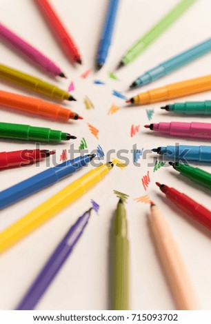 Top view of strokes painted with colorful markers on white paper. Group of different makers isolated