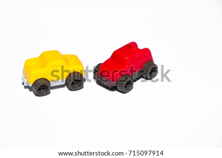 Two tiny simple toy cars, red & yellow, isolated on white horizontal background. Various concepts