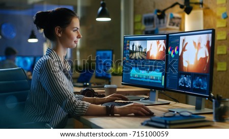 Beautiful Female Video Editor Works with Footage on Her Personal Computer, She Works in Creative Office Studio. Royalty-Free Stock Photo #715100059