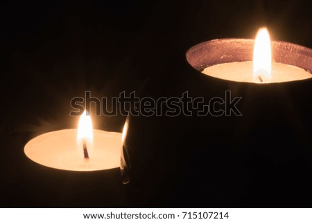 two candles burning and shining bright isolated on black background concept all saints day