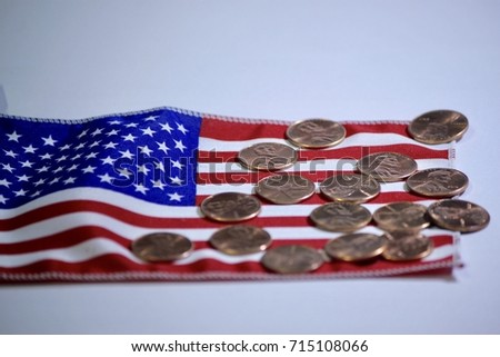 One cent coins (USD) currency money over the flag of the United States.
