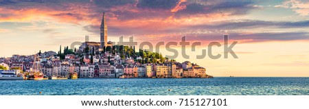 Great spring sunset of Rovinj town, Croatian fishing port on the west coast of the Istrian peninsula. Colorful evening seascape of Adriatic Sea. Traveling concept background.