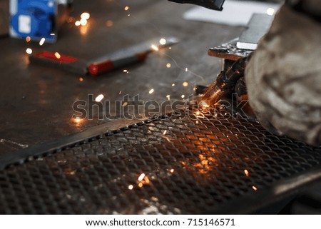 worker welding with groves and helmet protection