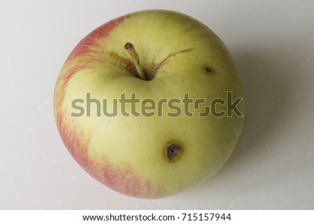 The Apple with a wormhole on a white background