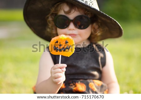 Little stylish witch outdoors, wearing halloween costume, ready for trick-or-treat