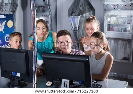 Young family is passing of quest room stylized under laboratory using a computer.