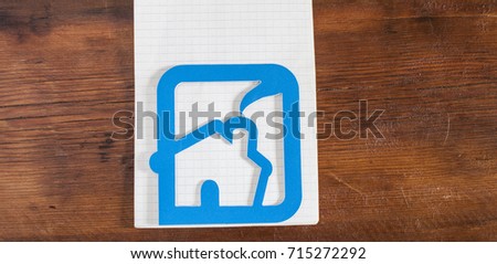 House icon made out of plastic on wooden background