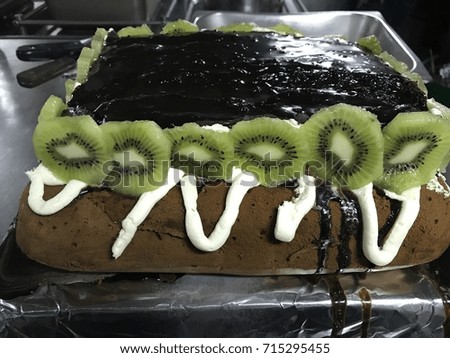 Delicious chocolate cake with chocolate topping on top and kiwi fruits 